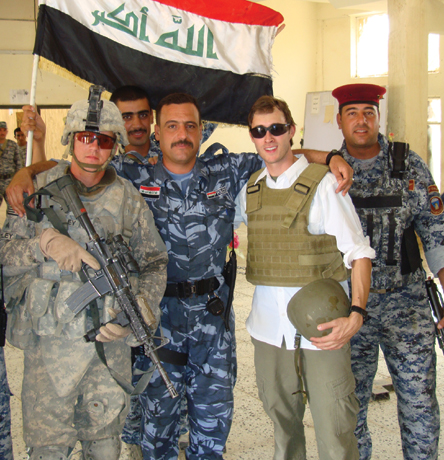 Adam stands with Iraqi police during his time embedded with the 101st Airborne. 